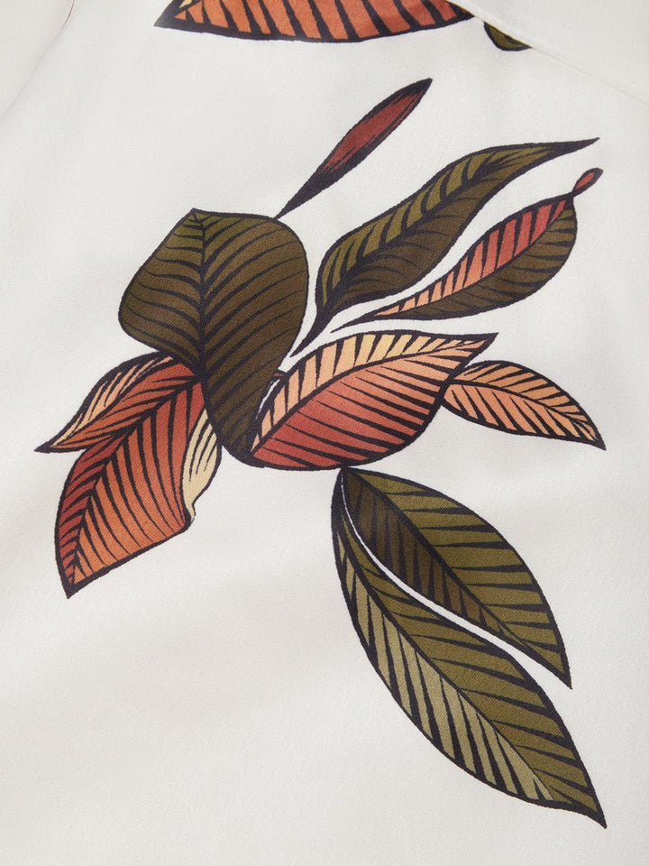 Close-up of white fabric with multicolor leaf print motif