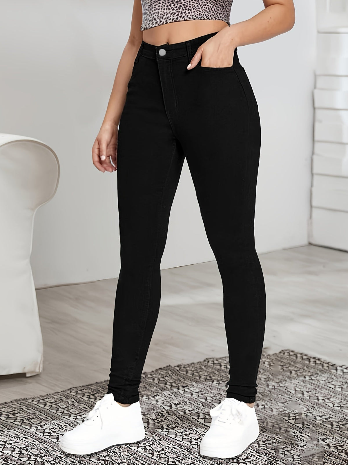 Black high-waist skinny jeans with button-and-zip front and belt loops