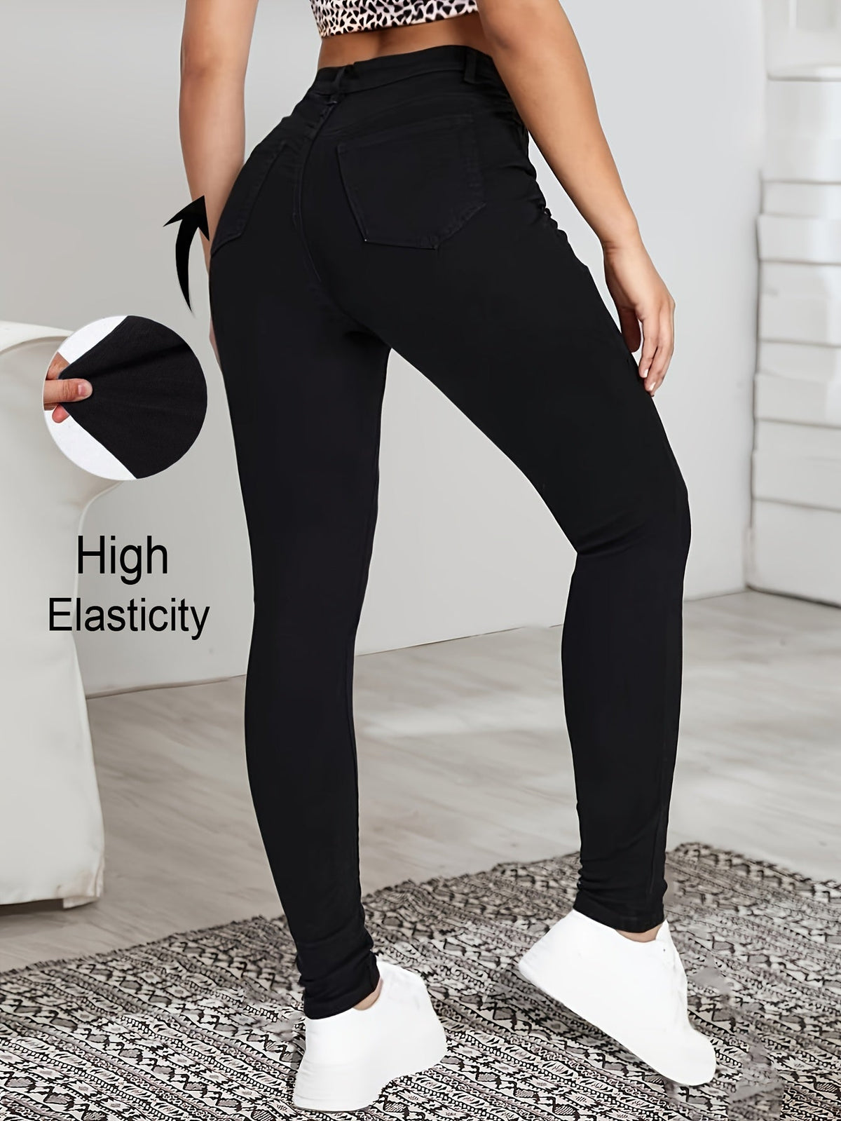 Black high-waist skinny jeans back view with back pockets and slim tapered legs