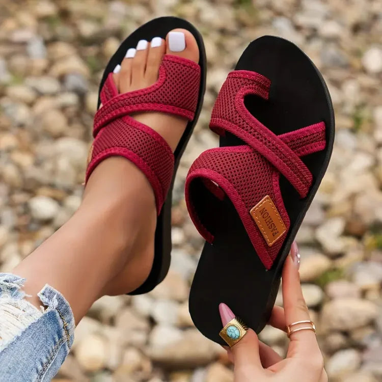 Red bunion corrector slide sandals with two straps and brown leather-look patch