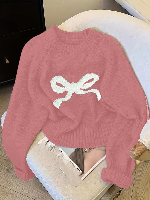 Rose pink knit sweater with ribbed crew neck, cuffs, and white bow intarsia