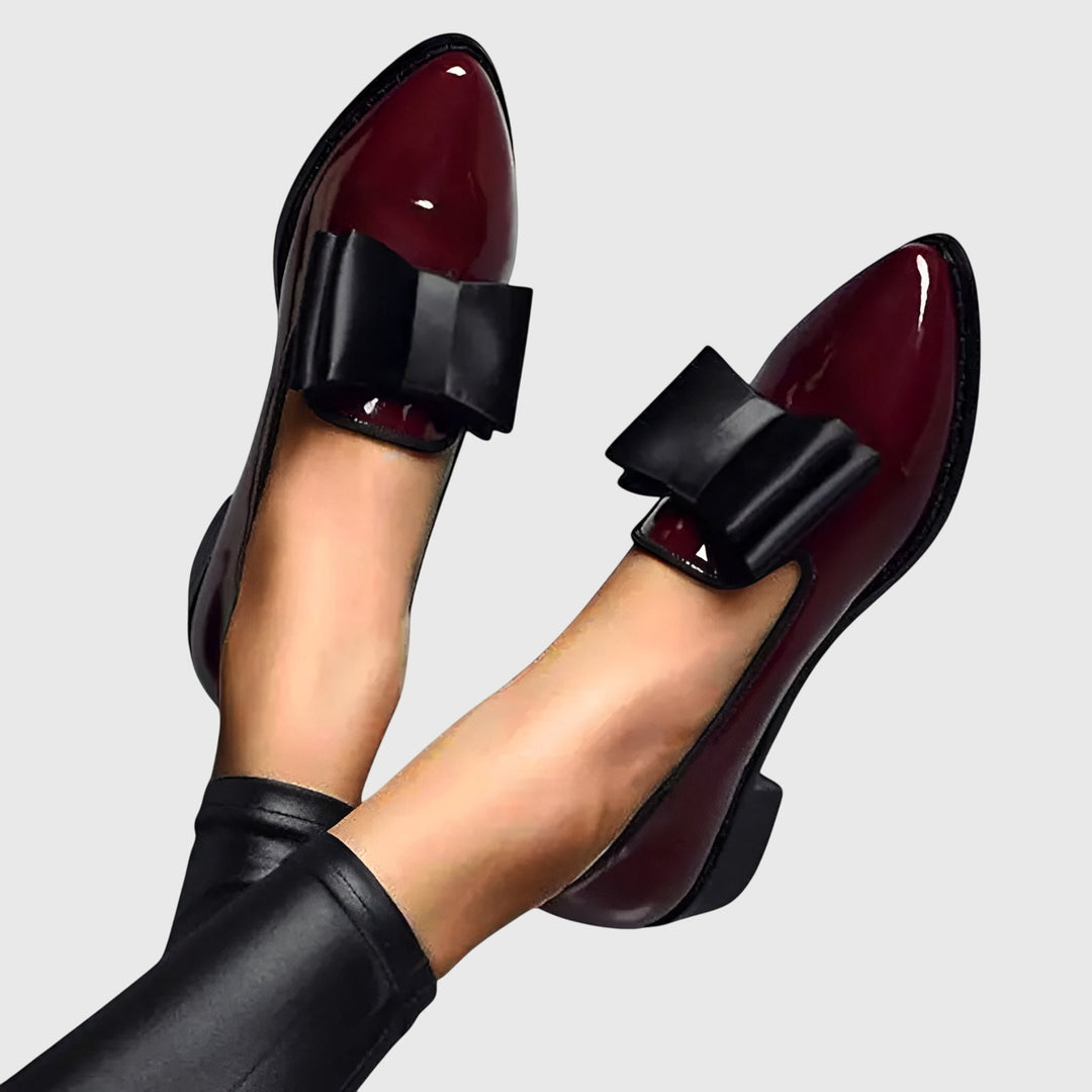 Burgundy patent loafer with black adjustable strap across the instep and rounded toe