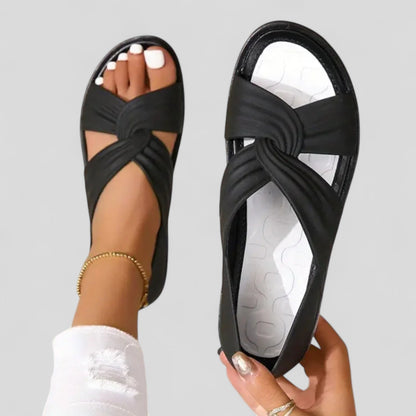 Black orthopedic sandals with open toe and knotted crossover strap, white tread sole