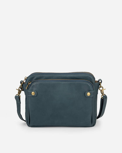 Teal-blue sleek crossbody bag with zip top, front pockets, and adjustable shoulder strap