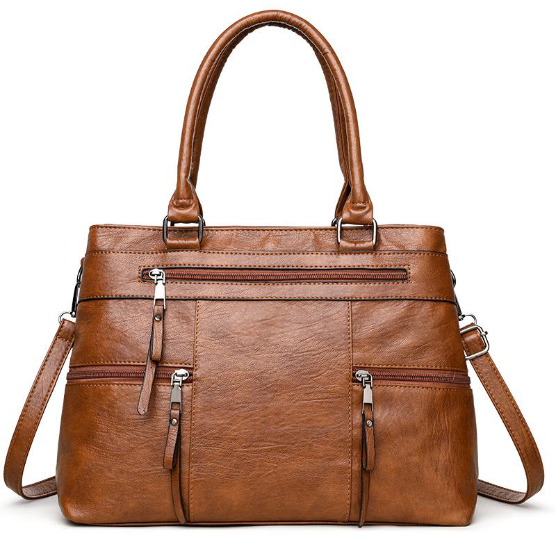 Caramel brown leather women’s tote bag with double top handles, front zip and crossbody strap