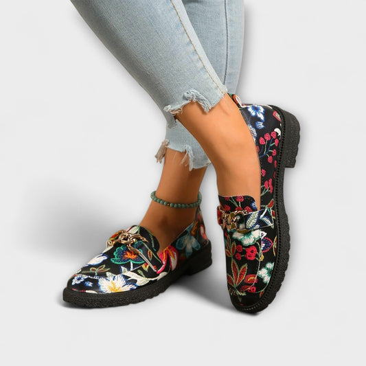 Multicolour floral loafers with gold chain buckle, black slip-on style, textured rubber sole