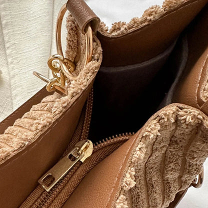 Corduroy tote bag detail with zipper, top edge trim, and leather shoulder straps