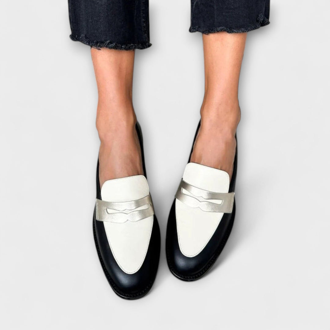 Two-tone metallic loafers with white metal straps and black soles, rolled denim