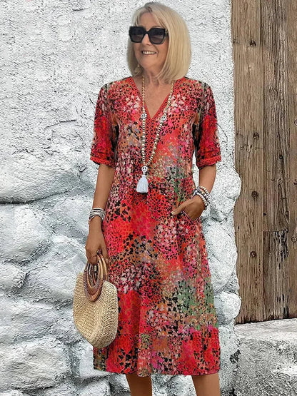 Mid-length V-neck dress in scarlet red with multicolor speckled pattern and tassel trim