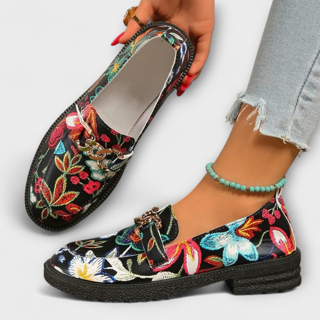 Multicolour floral slip-on loafers with gold chain buckle, black fabric upper and cushioned insole