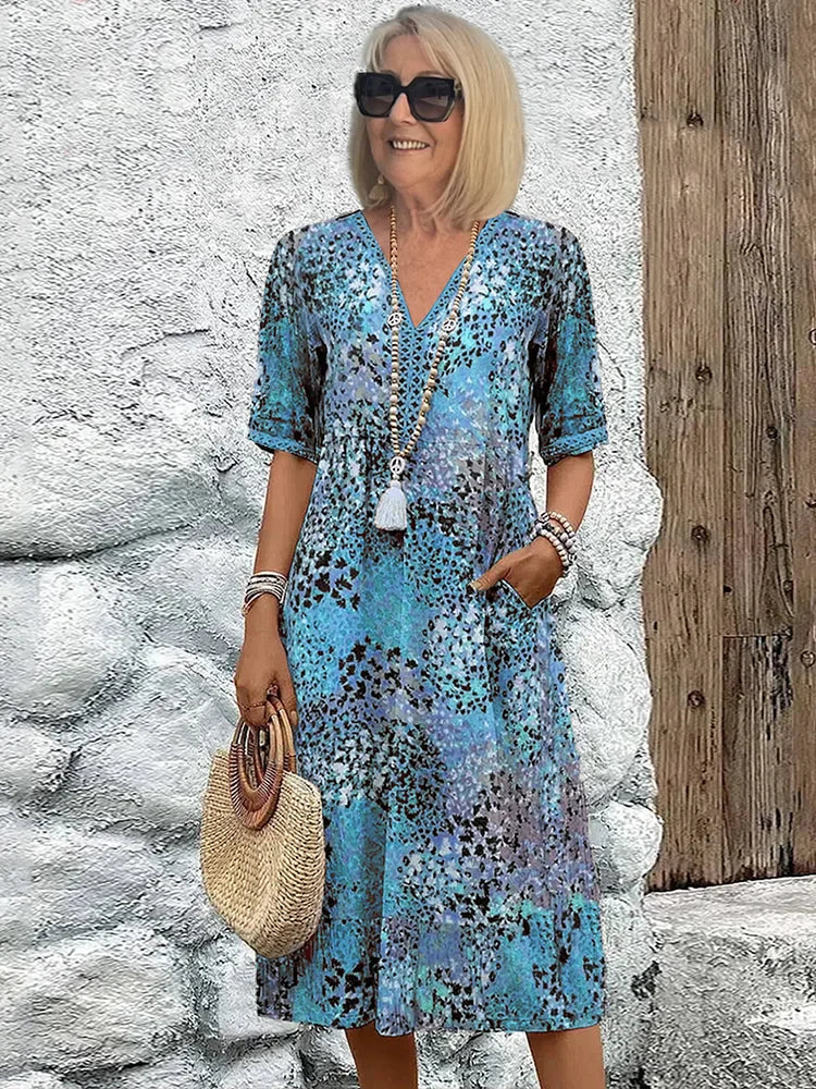 Mid-length V-neck dress in ocean blue with multicolor speckled pattern and tassel trim