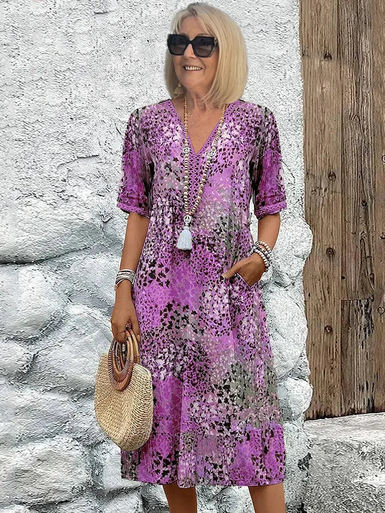 Mid-length V-neck dress in lavender purple with multicolor speckled pattern and tassel trim