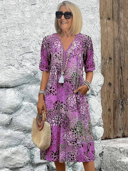 Mid-length V-neck dress in lavender purple with multicolor speckled pattern and tassel trim