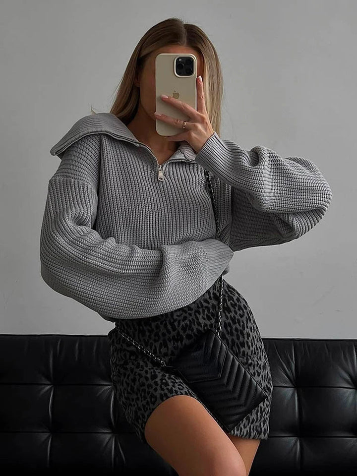 Gray knit half-zip sweater with long sleeves, stand collar, and front zipper