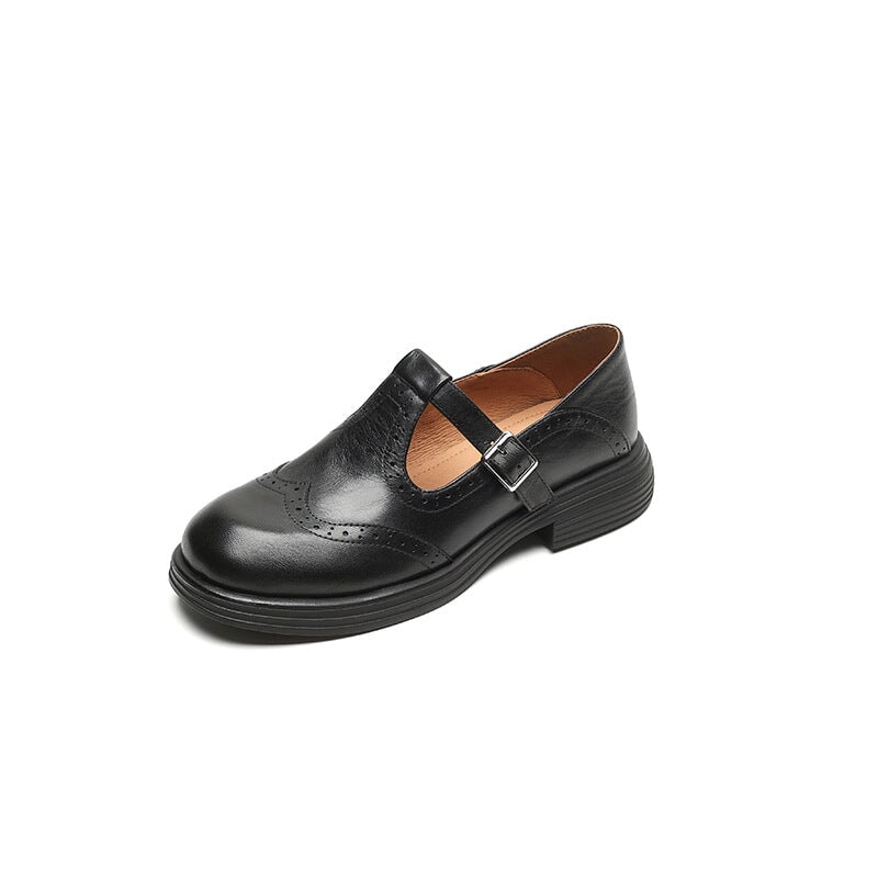 Black leather Mary Jane slip-on with buckle strap and wingtip stitching, low block heel.