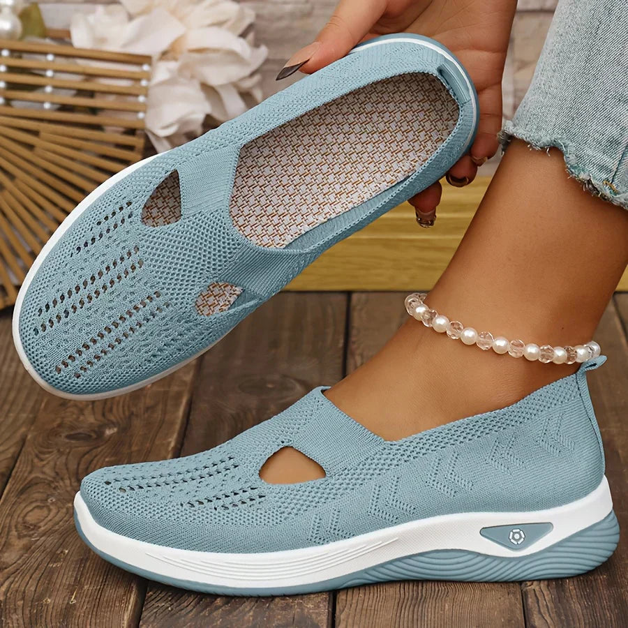 Light blue orthopedic slip-on shoes with knit upper, cutout openings, and white cushioned sole