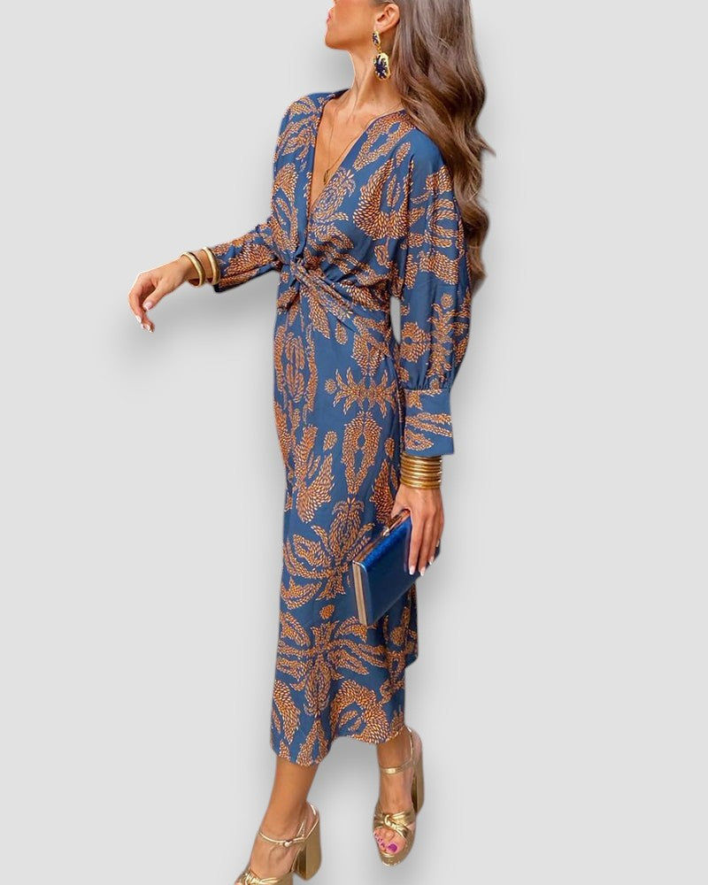 Blue V-neck wrap dress with long sleeves, patterned tie waist, and ornate leaf print.