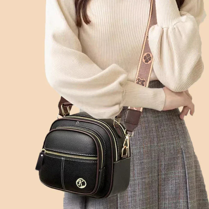 Dark mini crossbody shoulder bag with gold-tone hardware and adjustable crossbody strap