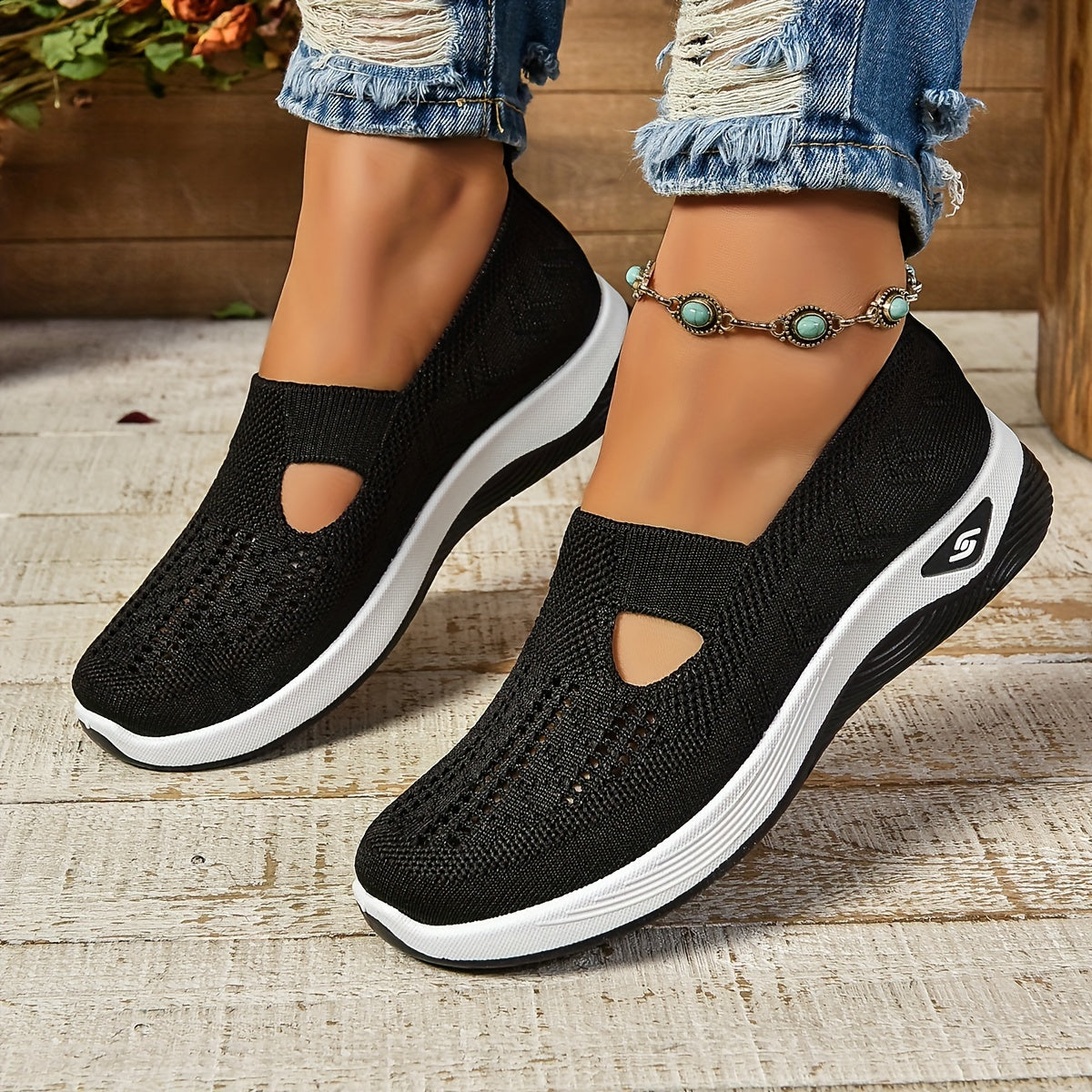 Black knit slip-on orthopedic shoes with side cutouts and white cushioned sole