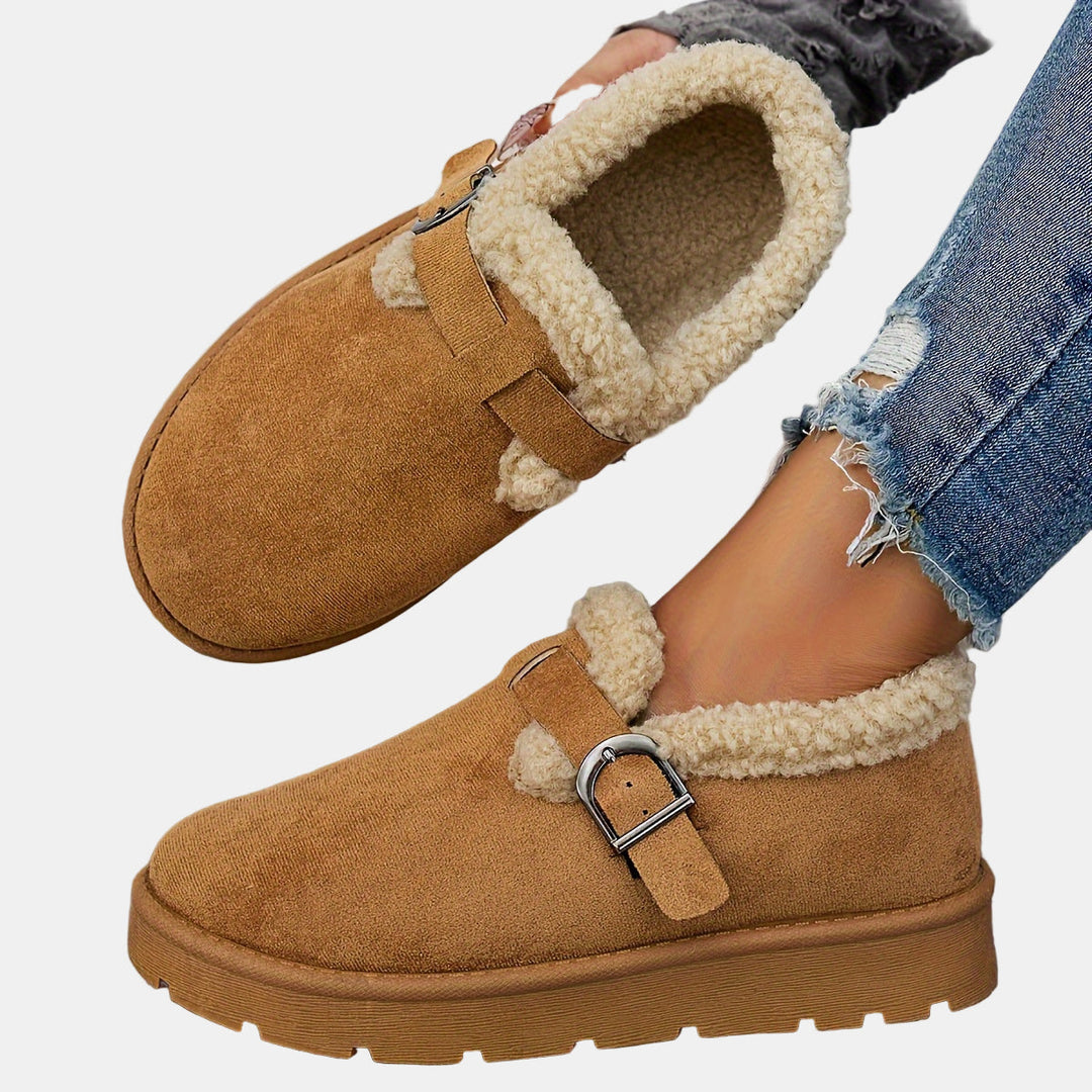 Brown fleece-lined ankle boot with shearling trim, buckled strap, thick tread sole