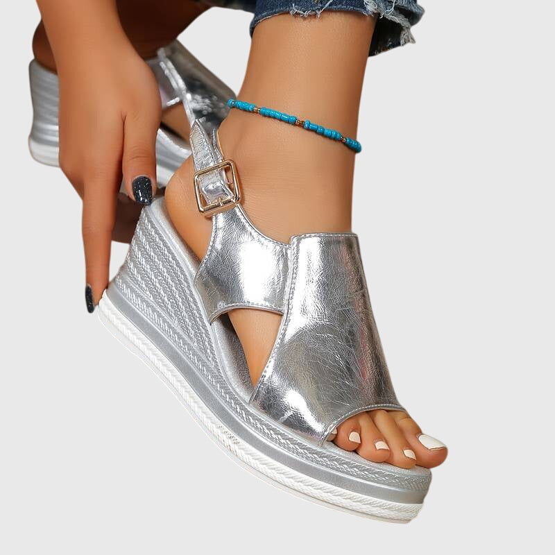 Silver metallic orthopedic wedge sandals with ankle strap and blue beaded bracelet