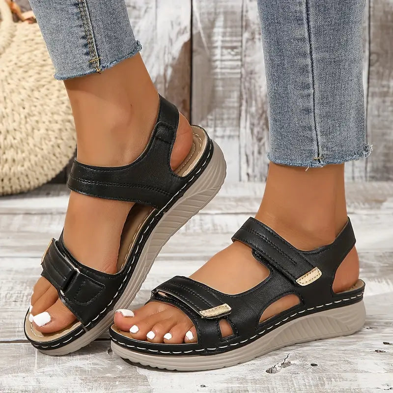 Black orthopedic sandals with open toe, front strap, and ankle strap on wedge sole