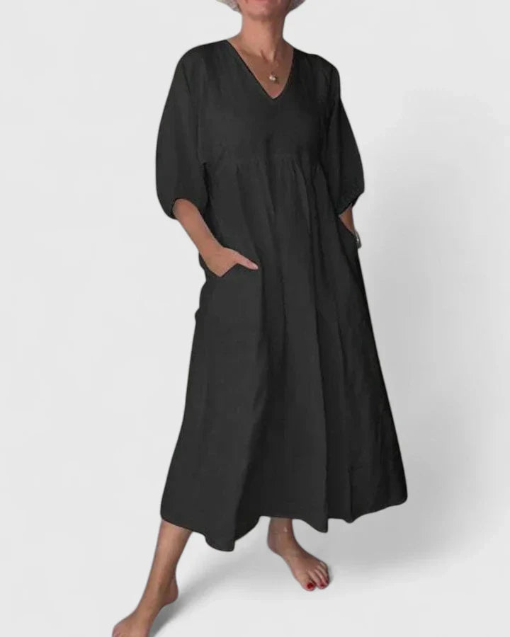 Black maxi dress with V-neck, three-quarter sleeves, and gathered waist seam