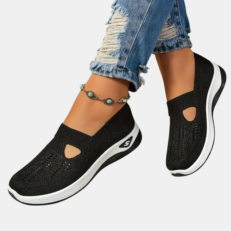 Black slip-on orthopedic walking shoe, knit upper with open toe cutouts, white sole.