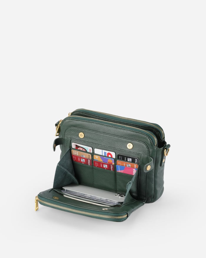 Jovie crossbody bag in deep green, open top showing card slots and zip compartments