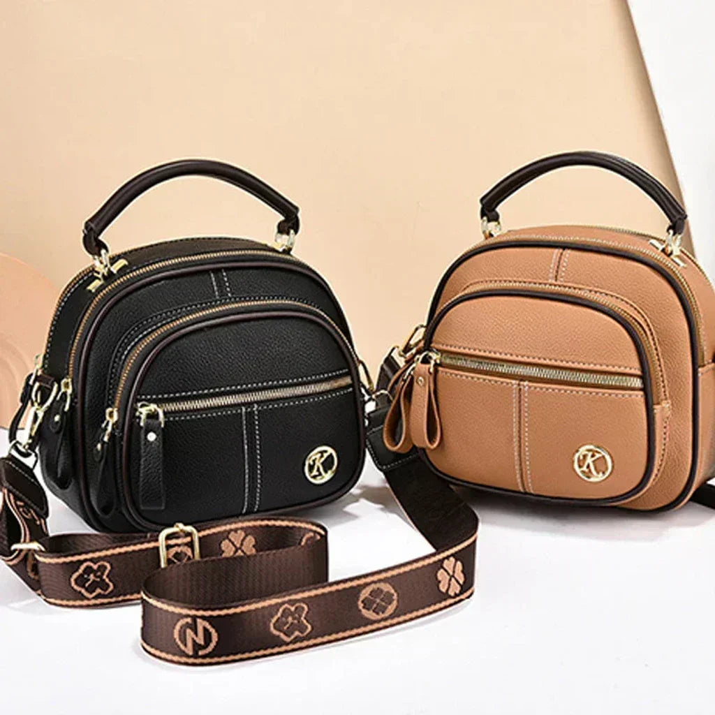 Black and tan mini crossbody bags with front zip pockets and logo emblems