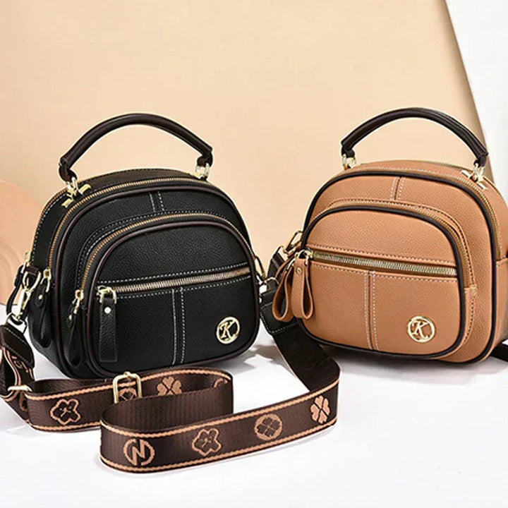 Black and tan mini crossbody bags with front zip pockets and logo emblems