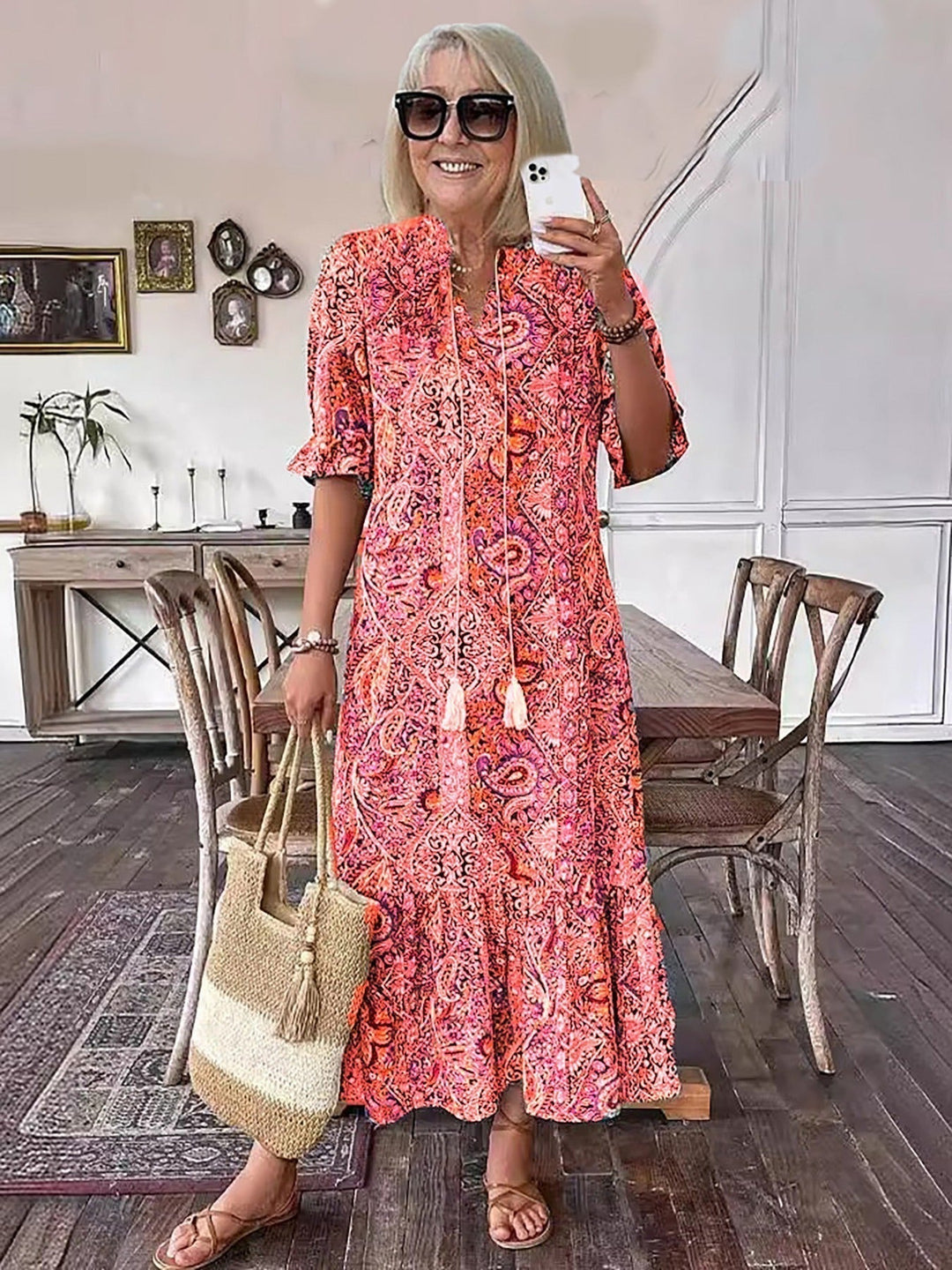 Boho grace dress in orange-red paisley print with tassel neckline, short puff sleeves, tiered skirt
