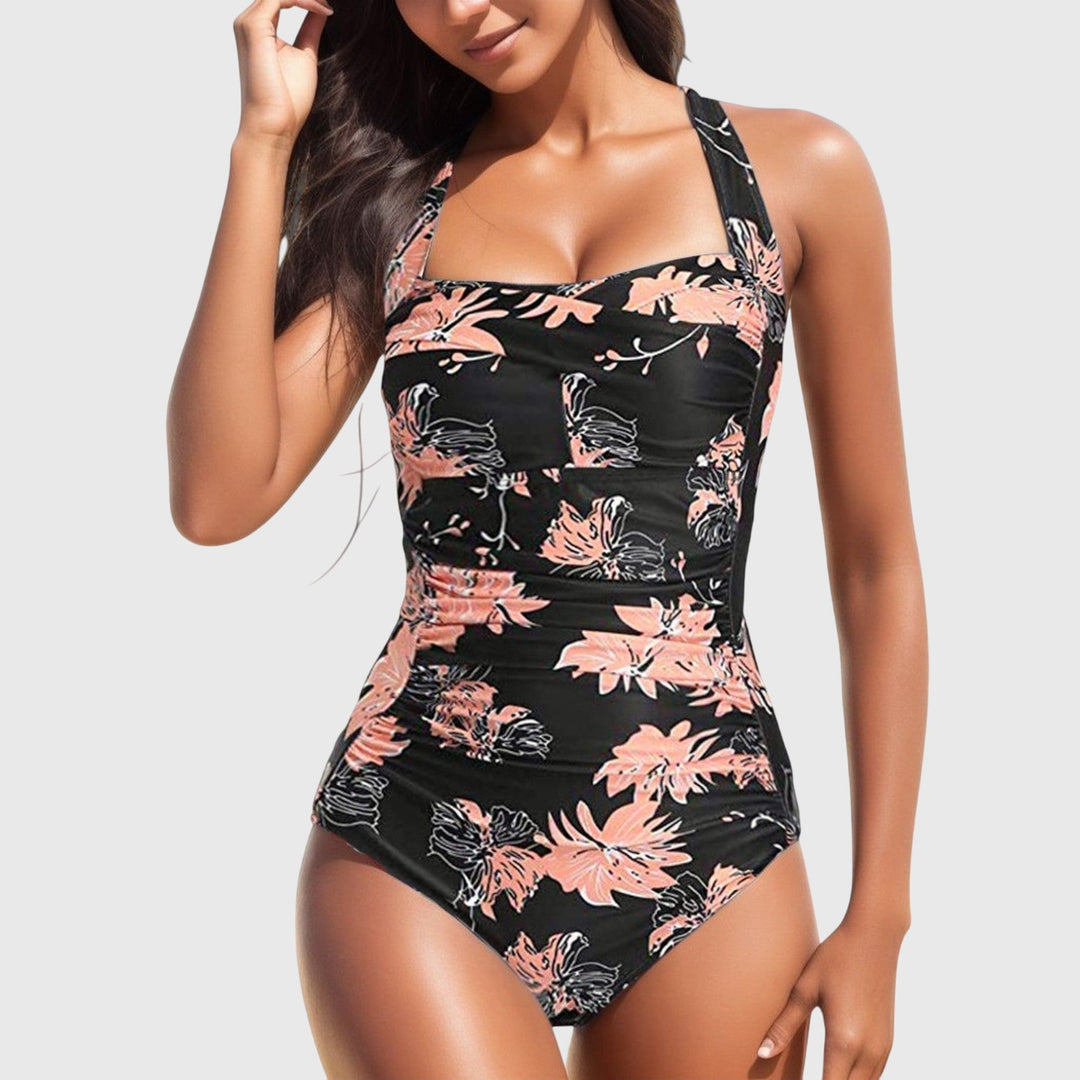 One-piece swimsuit, black with pink floral and orange leaf print and ruched fit.
