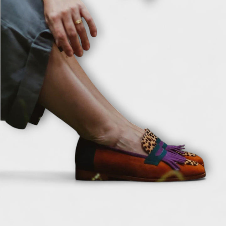 Brown leopard loafer on foot, purple fringe tassels and teal strap accents