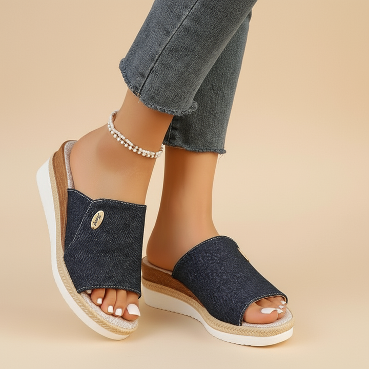 Dark navy denim ergonomic sandals with open toe and tan espadrille-style sole trim