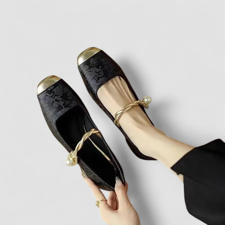 Pair of black orthopedic Mary Jane shoes with gold bow and capped toe