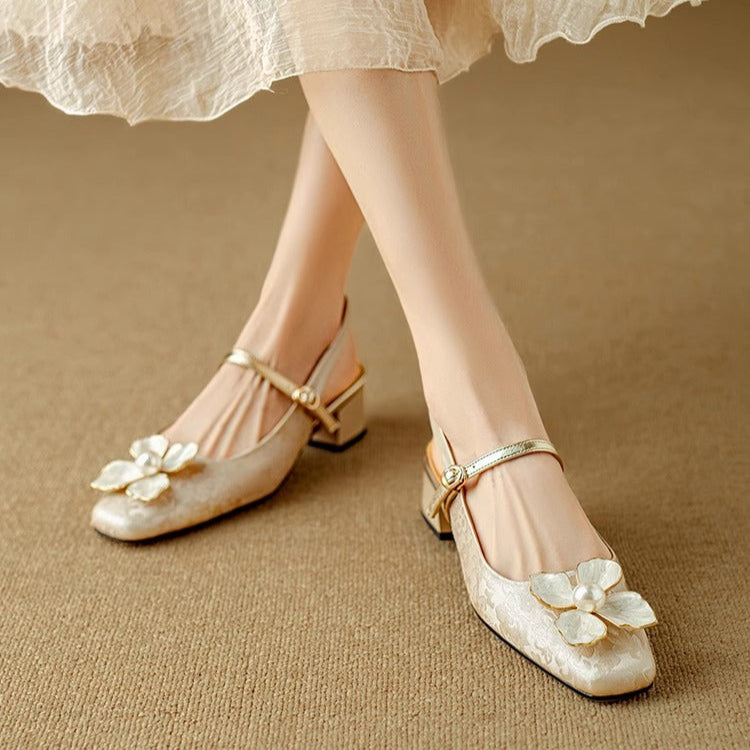 Beige pumps on short block heel with ankle strap and white flower appliques