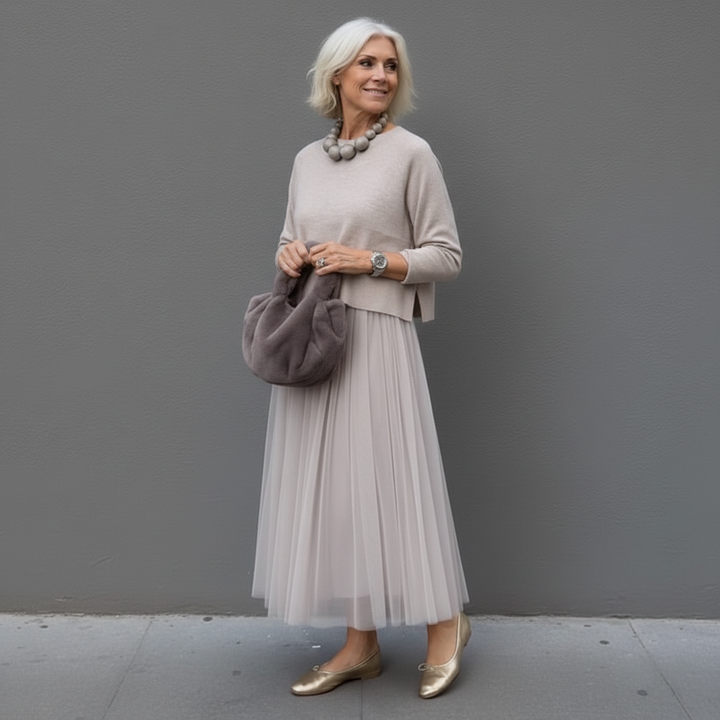 Light tan knit top layered with pale pleated tulle midi skirt