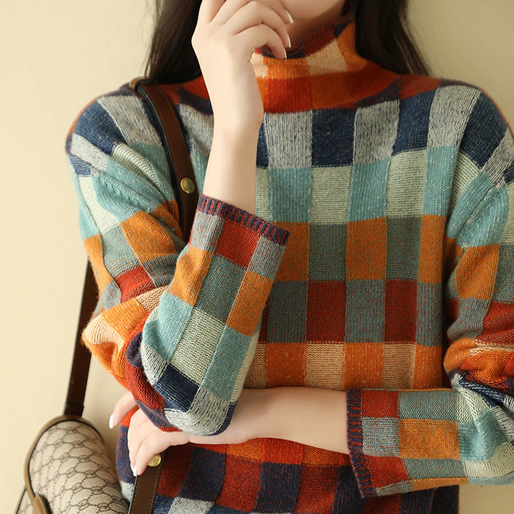 Plaid sweater with high crew neck and long sleeves; orange, teal, navy, and cream blocks.