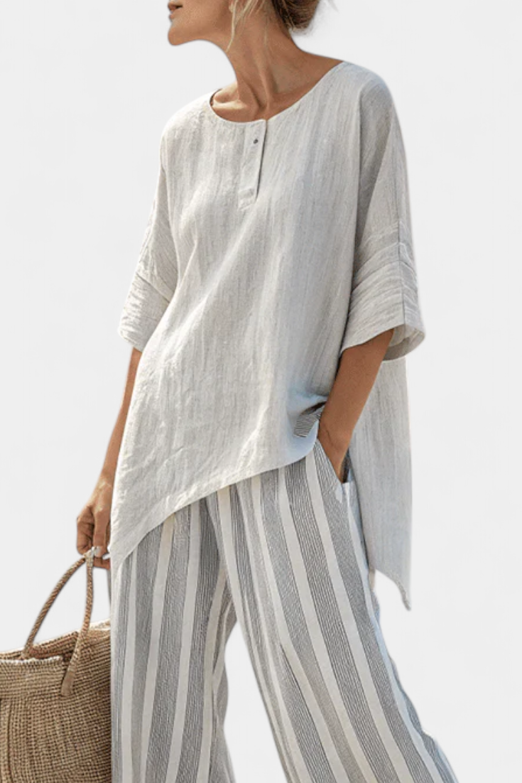 White asymmetric blouse with button placket; gray striped wide-leg trousers