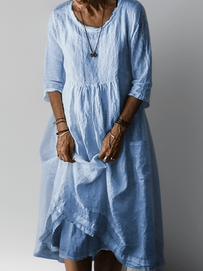 Blue flowing maxi dress with scoop neck, gathered waist, three-quarter sleeves and tiered hem