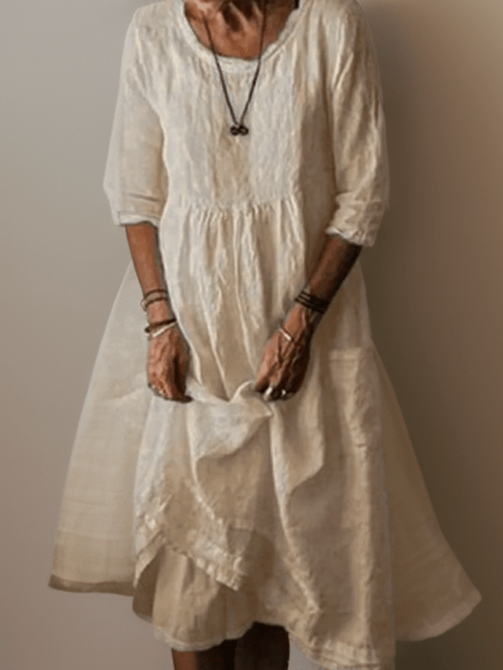 Cream flowing maxi dress with scoop neck, gathered waist, three-quarter sleeves and tiered hem