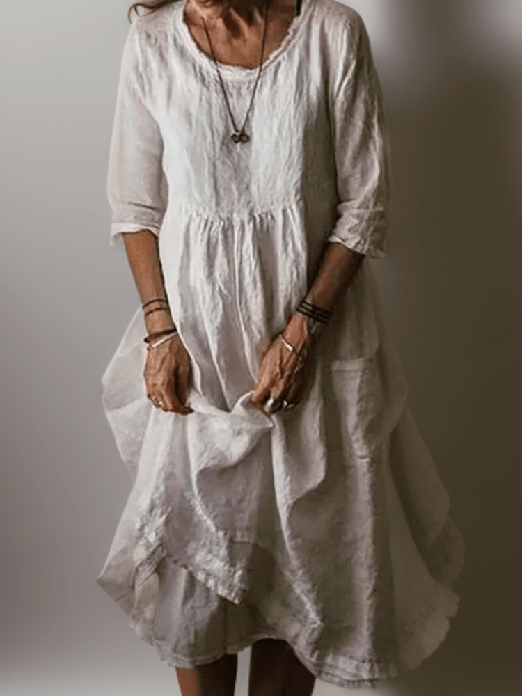 White flowing maxi dress with scoop neck, gathered waist, three-quarter sleeves and pleated tiered skirt