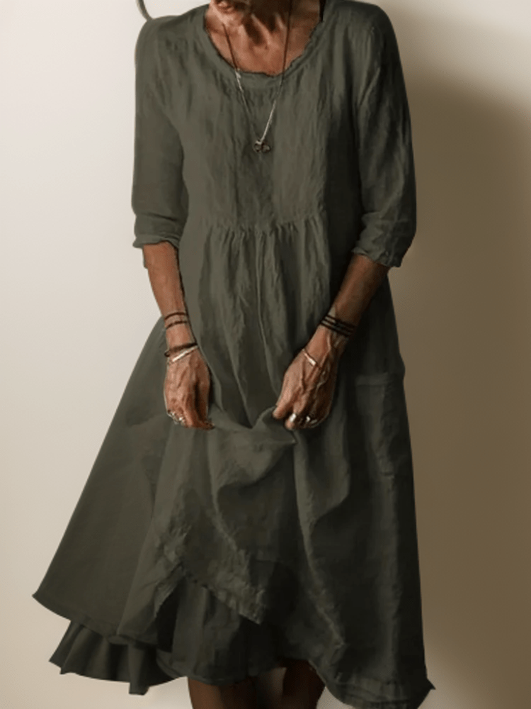 Dark green flowing maxi dress with scoop neck, gathered waist, three-quarter sleeves and tiered hem