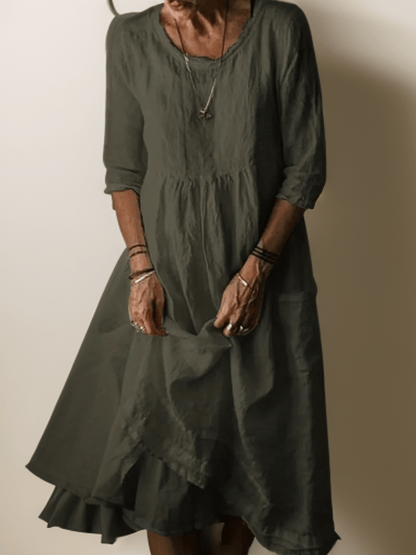 Dark green flowing maxi dress with scoop neck, gathered waist, three-quarter sleeves and tiered hem