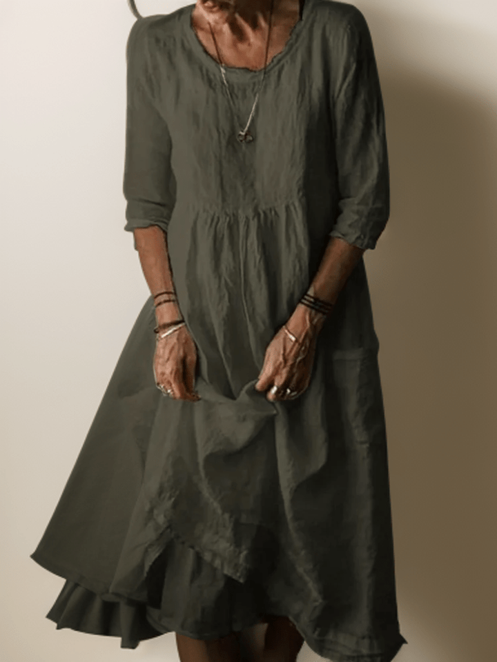 Dark green flowing maxi dress with scoop neck, gathered waist, three-quarter sleeves and tiered hem
