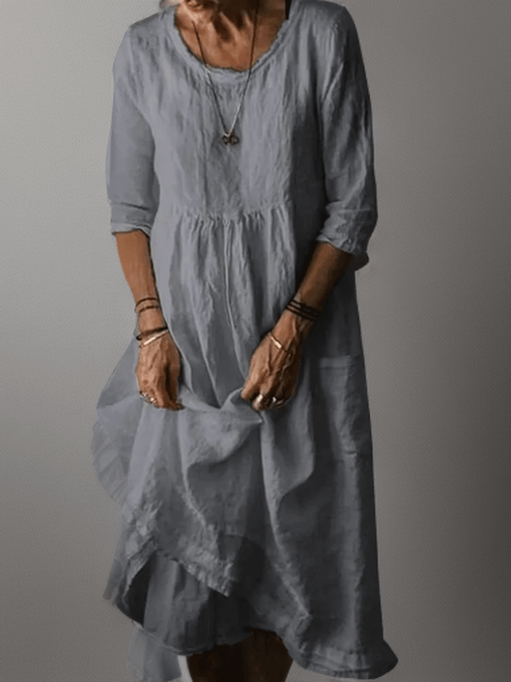 Grey-blue flowing maxi dress with scoop neck, gathered waist, three-quarter sleeves and tiered hem