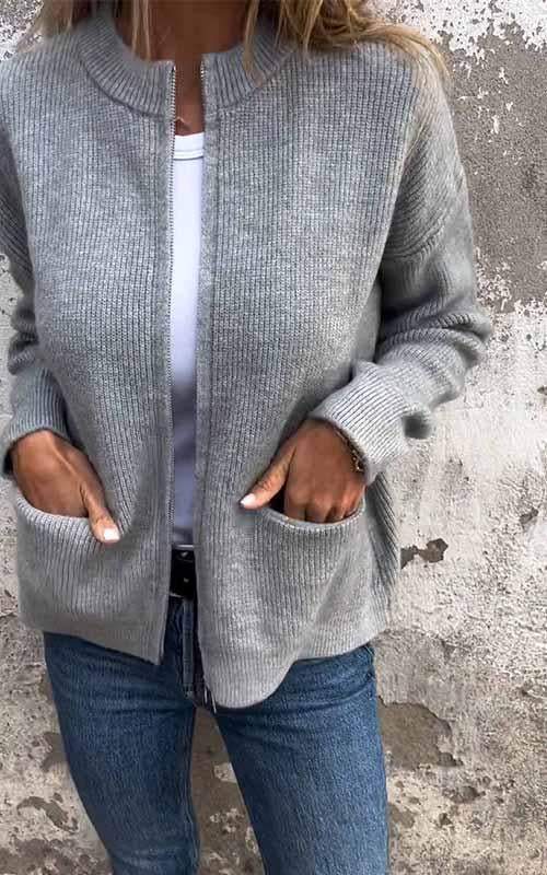 Grey zip-up knit cardigan with ribbed collar, front zipper, and side pockets.