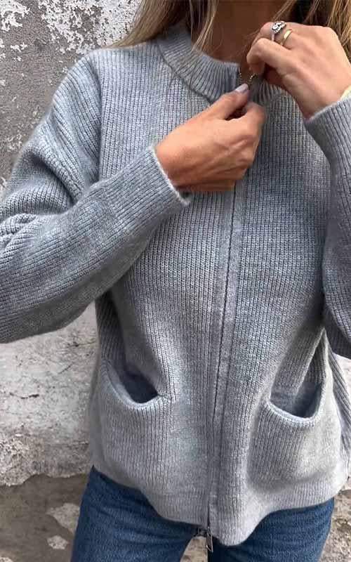 Grey zip-up knit cardigan with ribbed stand collar, front zipper, and side pockets.