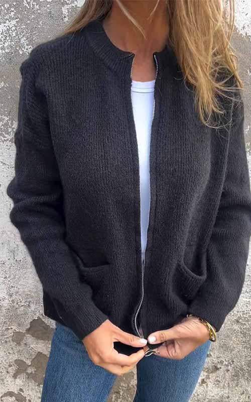 Black zip-up knit cardigan with ribbed trim, front zipper, and side pockets.